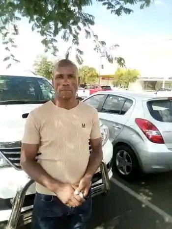 Missing uncle in Pretoria | Help Find Timothy Hlongwane (53) 2 Timothy Mandla Hlongwane, missing uncle standing in a parking lot with several cars behind him