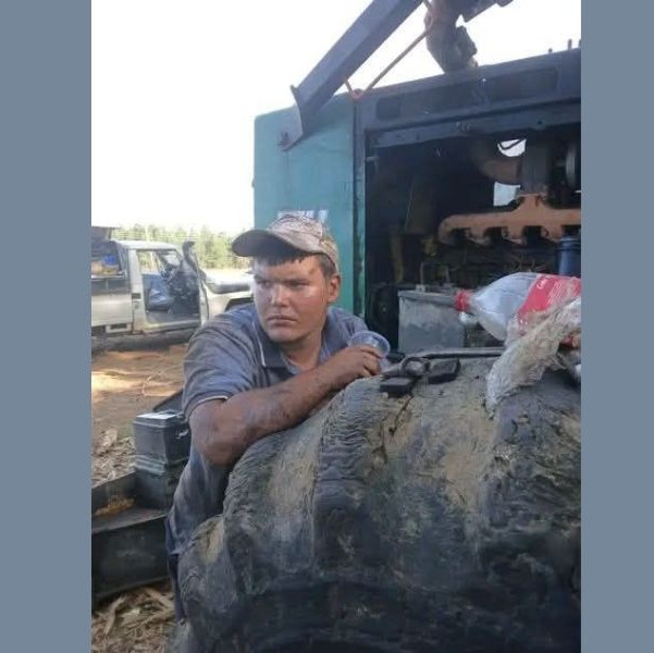 Reuben Marsberg working as a diesel mechanic, covered in oil at his job